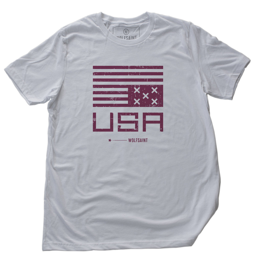 Classic bold graphic t-shirt with a political statement of an upside-down American flag, with Xs instead of stars, and the bold letters "USA" and the brand Wolfsaint below.
