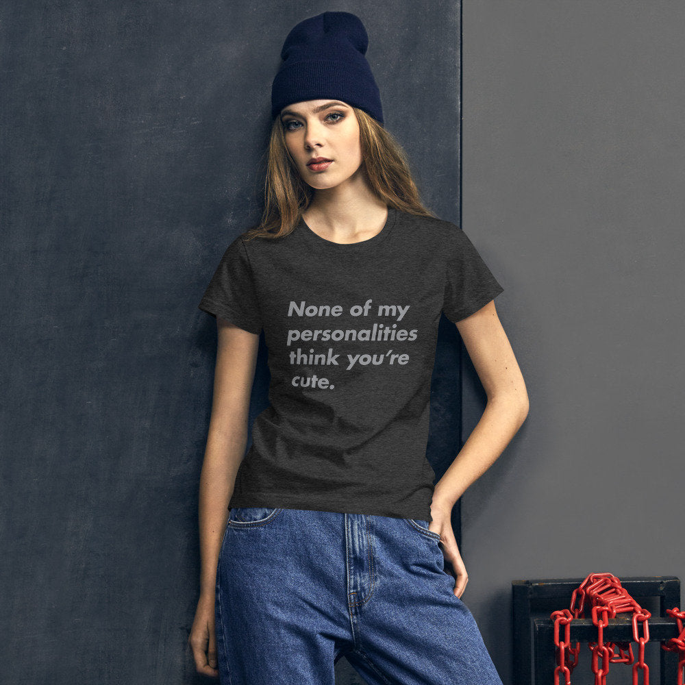 Female model wearing a simple graphic tee featuring the sarcastic words "None of my personalities think you're cute."
