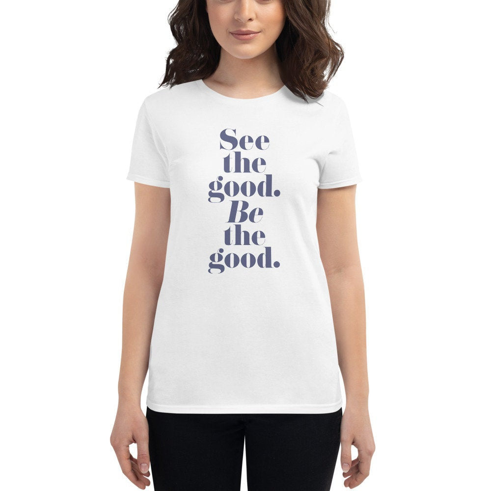 Female model wearing the women's cut graphic t-shirt featuring the positive, inspirational words "See the good. BE the good" in classic, elegant typography.