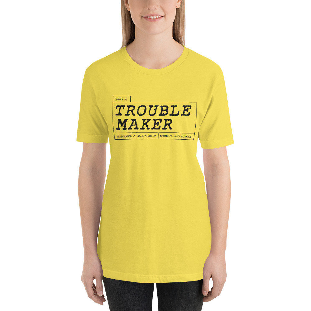 Female model wearing a graphic t-shirt in a classic retro style, with the words "Trouble Maker, bona fide"